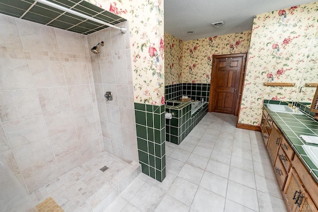 bathroom featuring a textured ceiling, wallpapered walls, and a tile shower