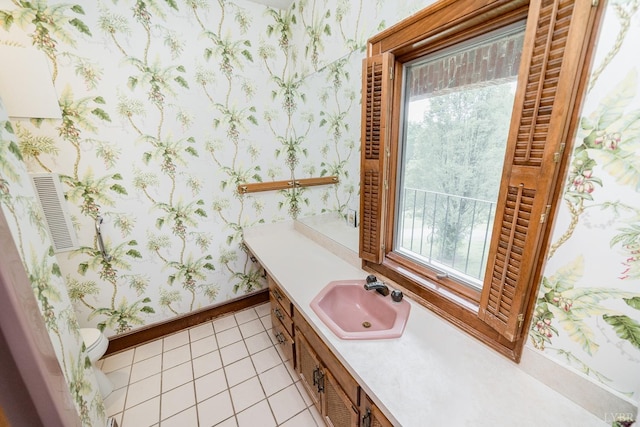 bathroom with tile patterned floors, wallpapered walls, baseboards, and vanity