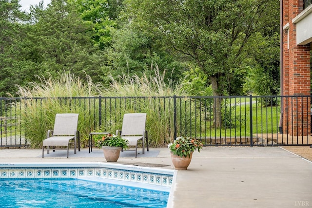 view of swimming pool with a patio, fence, and a fenced in pool