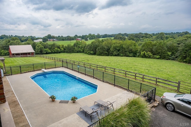 view of pool with a lawn, fence, a rural view, and a fenced in pool