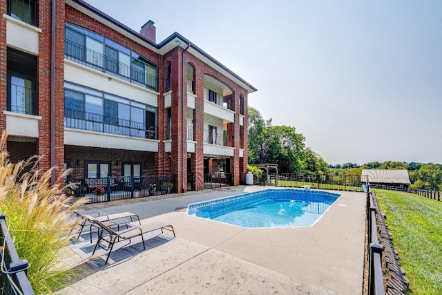view of swimming pool featuring fence, a fenced in pool, and a patio area