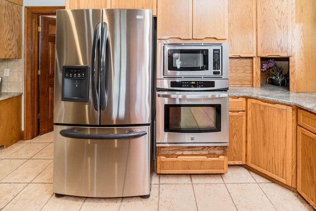 kitchen featuring light tile patterned flooring, tasteful backsplash, and appliances with stainless steel finishes