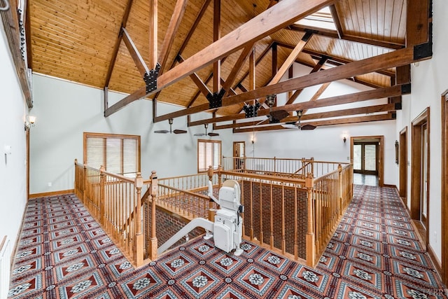 hallway with an upstairs landing, high vaulted ceiling, a healthy amount of sunlight, and wooden ceiling
