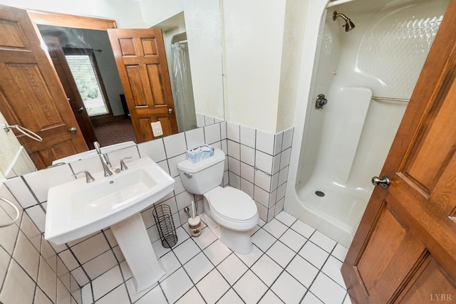 bathroom featuring tile walls, toilet, and a shower stall
