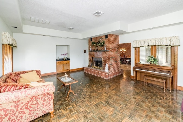 living area featuring baseboards, visible vents, and a textured ceiling