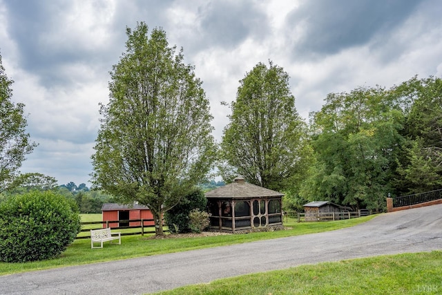 surrounding community featuring an outbuilding, a gazebo, fence, and a lawn