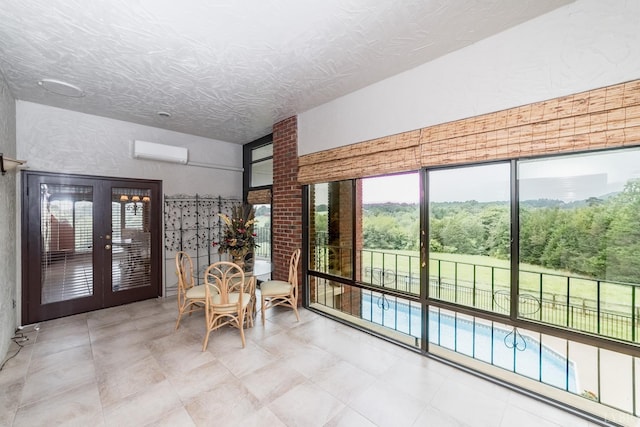 interior space featuring french doors, an AC wall unit, and a textured ceiling