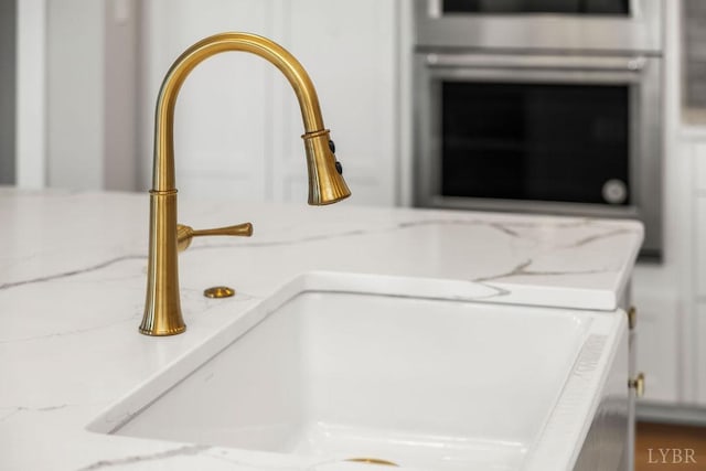 room details featuring a sink and stainless steel oven