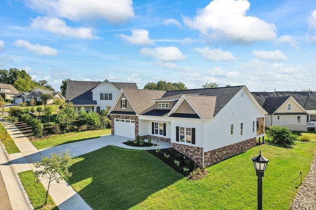 view of front facade with a front yard, a residential view, concrete driveway, stone siding, and roof with shingles