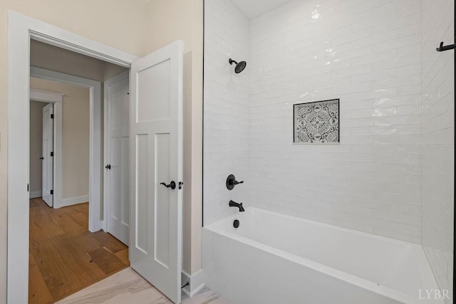 full bath with baseboards and shower / bath combination