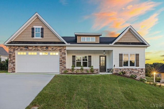 craftsman-style home with a front yard, a standing seam roof, stone siding, and driveway