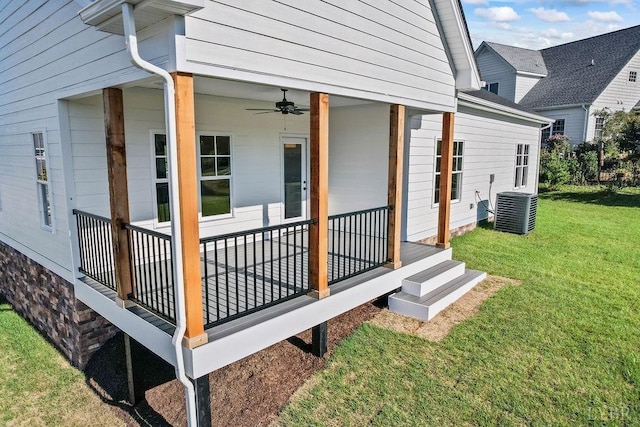 exterior space with cooling unit, a yard, and a ceiling fan