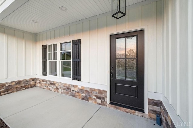property entrance with stone siding and board and batten siding