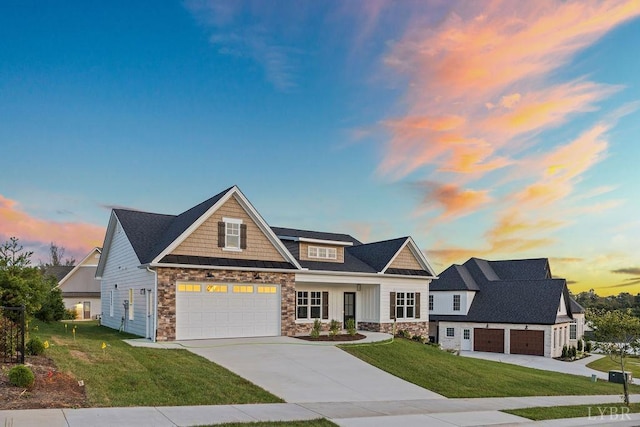craftsman-style home featuring stone siding, concrete driveway, an attached garage, and a lawn