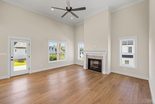 unfurnished living room with a wealth of natural light, ornamental molding, and a high ceiling
