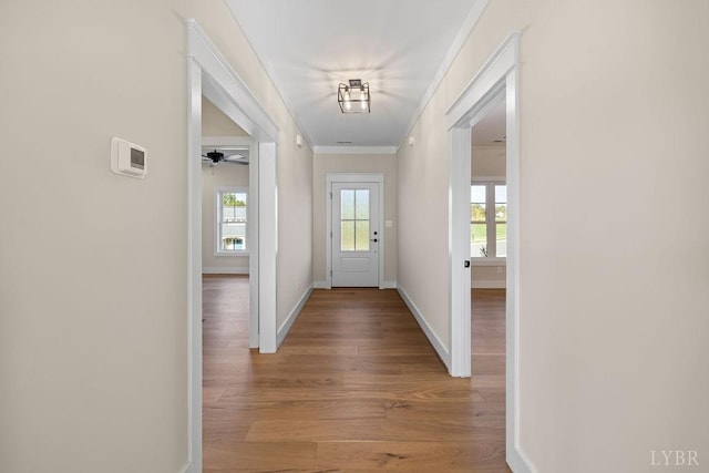 entryway with baseboards, light wood-style flooring, and ornamental molding