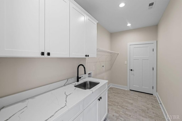 washroom with a sink, cabinet space, visible vents, recessed lighting, and washer hookup