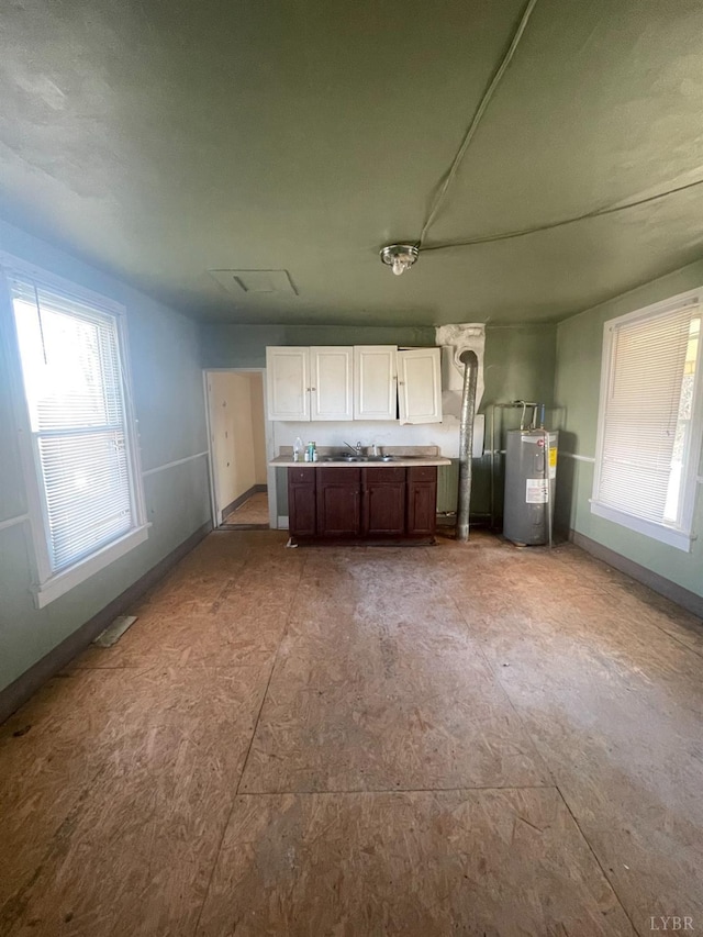 500 Amherst St, Lynchburg, VA 24504 - kitchen featuring baseboards, water heater, a sink, light countertops, and white cabinetry