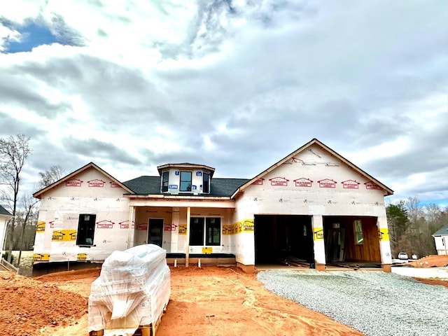 property in mid-construction featuring gravel driveway and an attached garage