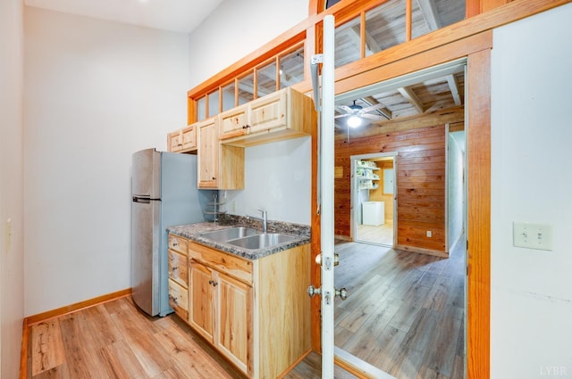 1343 Wares Gap Rd, Monroe, VA 24574 - kitchen featuring light brown cabinetry, a sink, light wood-style floors, wooden walls, and freestanding refrigerator