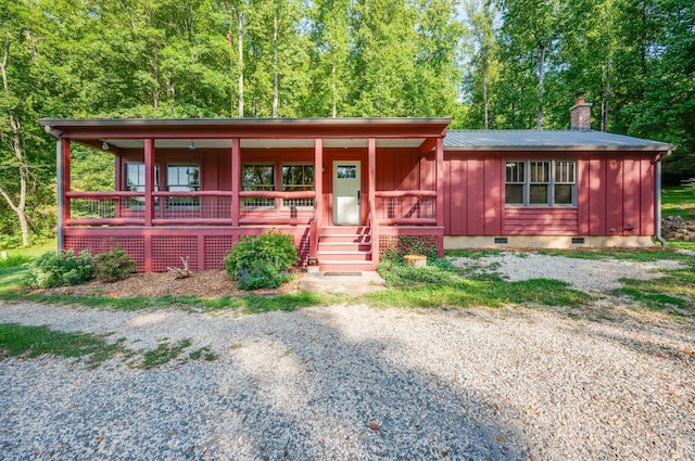 view of front of property featuring crawl space, a chimney, a porch, and board and batten siding