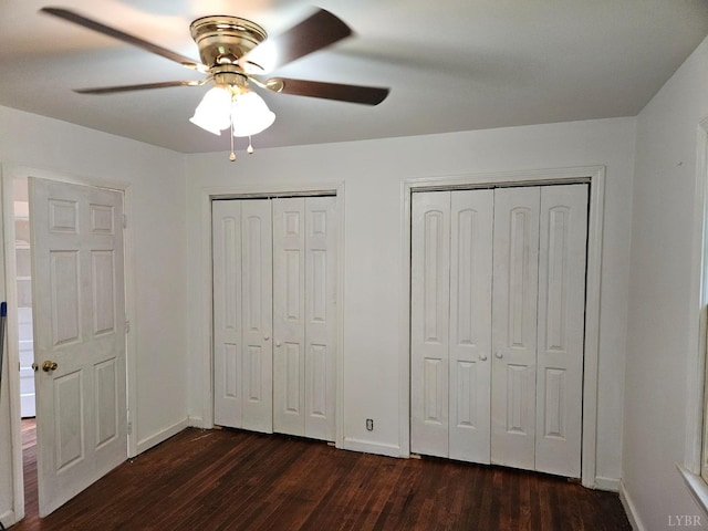 119 Caroline Ave, Brookneal, VA 24528 - unfurnished bedroom featuring two closets, dark wood-style floors, and a ceiling fan