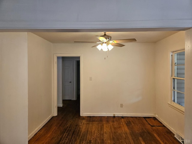 empty room featuring baseboards, dark wood-style flooring, visible vents, and ceiling fan