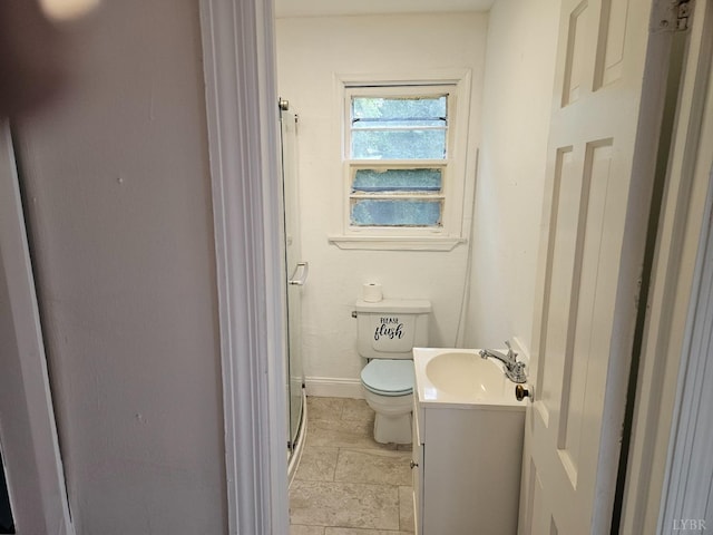 bathroom featuring toilet, baseboards, a shower with shower door, and vanity
