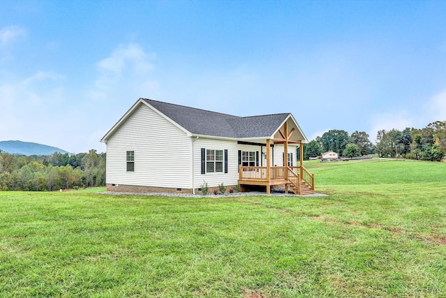 rear view of property with a yard, crawl space, and roof with shingles