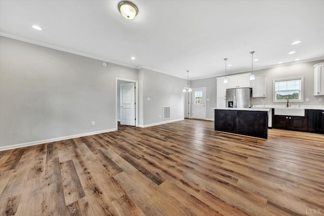 1095 Fox Ln, Moneta, VA 24121 - unfurnished living room featuring healthy amount of natural light, light wood-style floors, a sink, baseboards, and ornamental molding