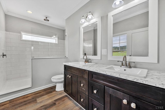 full bath featuring crown molding, a sink, and walk in shower