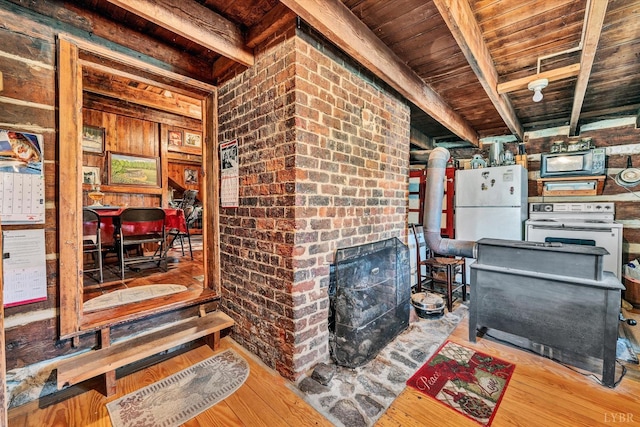 interior space featuring white fridge, wood walls, a fireplace, wooden ceiling, and light wood-type flooring