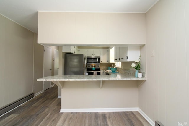 5427 Snake Creek Rd, Stuart, VA 24343 - kitchen with stainless steel appliances, a baseboard heating unit, wood finished floors, and light countertops
