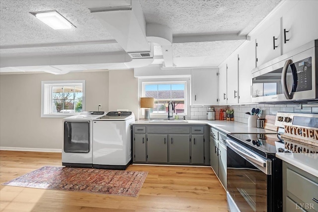 2180 Lime Plant Rd, Appomattox, VA 24522 - kitchen with appliances with stainless steel finishes, washer and dryer, a sink, gray cabinetry, and a textured ceiling