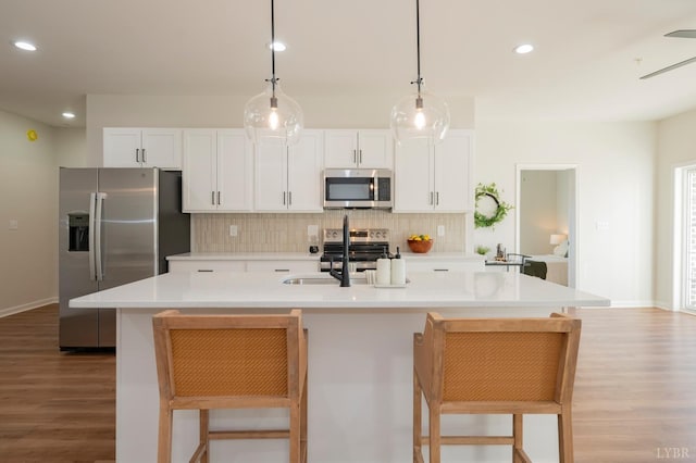 128 Brenleigh Ct Unit 308, Lynchburg, VA 24501 - kitchen featuring stainless steel appliances, wood finished floors, a sink, tasteful backsplash, and white cabinets