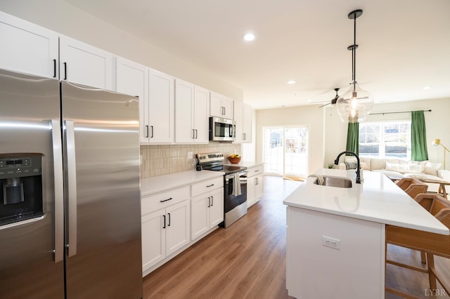 128 Brenleigh Ct Unit 308, Lynchburg, VA 24501 - kitchen featuring appliances with stainless steel finishes, a sink, decorative backsplash, open floor plan, and white cabinetry