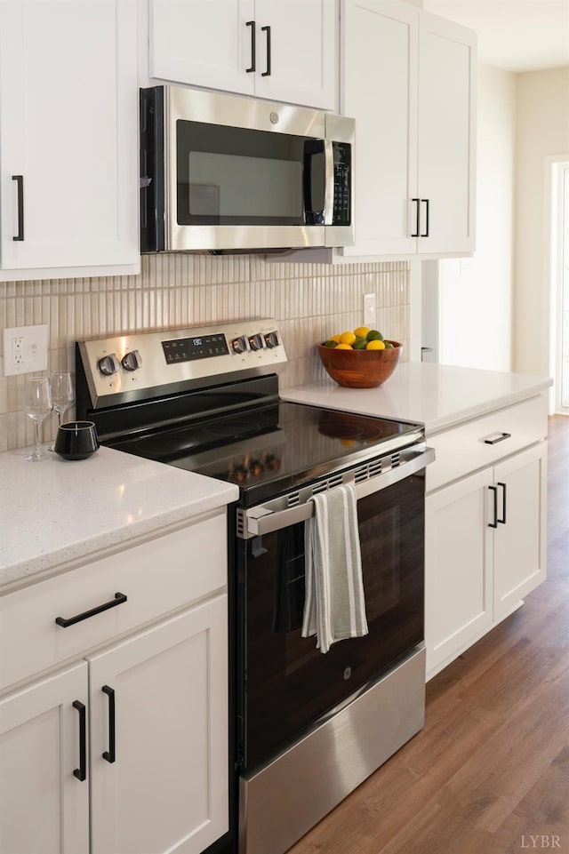 128 Brenleigh Ct Unit 308, Lynchburg, VA 24501 - kitchen featuring stainless steel appliances, light wood finished floors, white cabinets, and tasteful backsplash