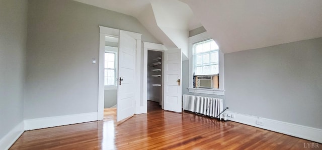 4065 Fort Ave, Lynchburg, VA 24502 - unfurnished bedroom featuring radiator heating unit, wood finished floors, lofted ceiling, baseboards, and cooling unit