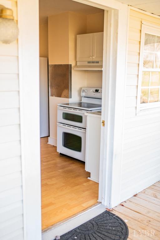 67 Lentz Ln, Shipman, VA 22971 - kitchen with double oven range, under cabinet range hood, light wood finished floors, and white cabinetry