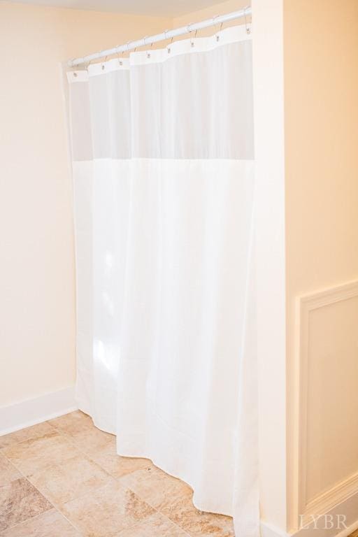 67 Lentz Ln, Shipman, VA 22971 - bathroom featuring baseboards and curtained shower