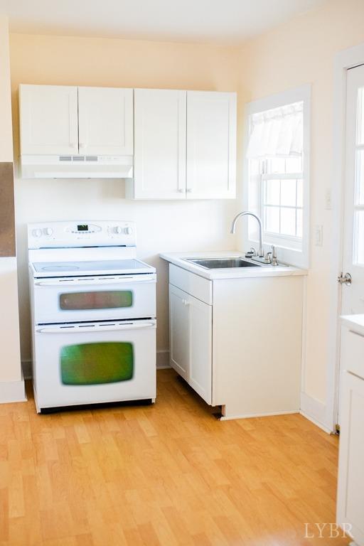 67 Lentz Ln, Shipman, VA 22971 - kitchen with range with two ovens, a sink, under cabinet range hood, white cabinets, and light wood finished floors