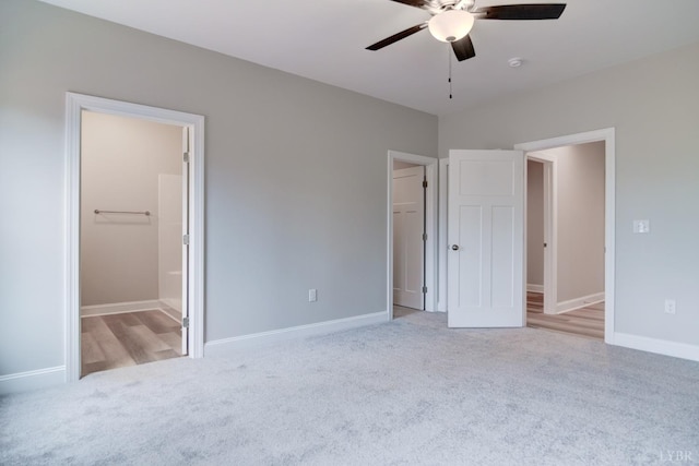 1327 Greenhouse Rd, Rustburg, VA 24588 - unfurnished bedroom featuring a ceiling fan, baseboards, ensuite bath, a walk in closet, and light colored carpet