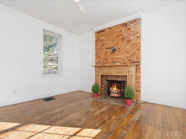 522 Jackson St, Lynchburg, VA 24504 - unfurnished living room with a brick fireplace, baseboards, and hardwood / wood-style flooring