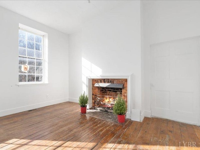 522 Jackson St, Lynchburg, VA 24504 - unfurnished living room featuring hardwood / wood-style flooring, a fireplace with flush hearth, and baseboards