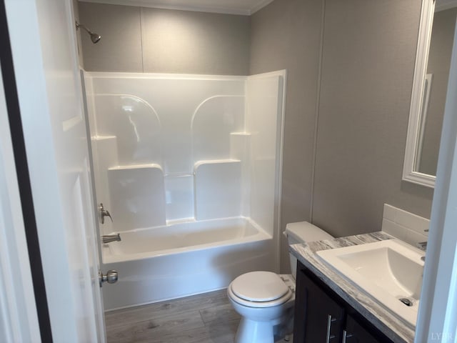 bathroom featuring toilet, vanity, shower / tub combination, and wood finished floors