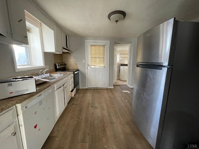 3221 Maryland Ave, Lynchburg, VA 24501 - kitchen with appliances with stainless steel finishes, a sink, a textured ceiling, hardwood / wood-style floors, and under cabinet range hood
