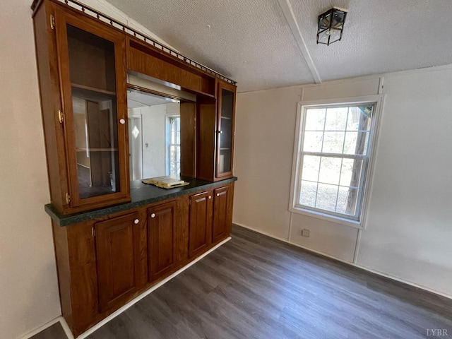 spare room featuring dark wood-type flooring and a textured ceiling