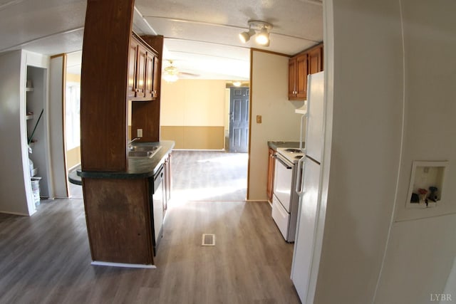 kitchen with wood finished floors, electric range, dark countertops, and stainless steel dishwasher