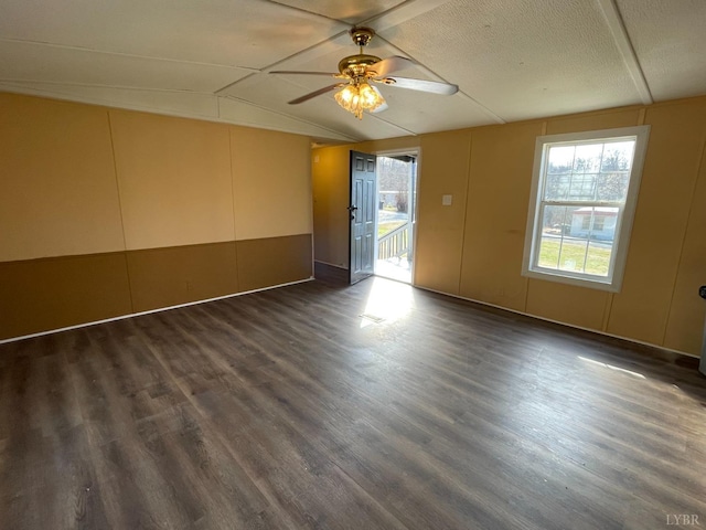 spare room featuring plenty of natural light, lofted ceiling, dark wood-type flooring, and ceiling fan