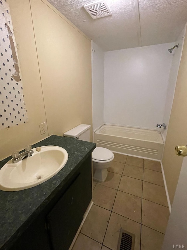 bathroom with tile patterned floors, toilet, shower / bathtub combination, vanity, and a textured ceiling